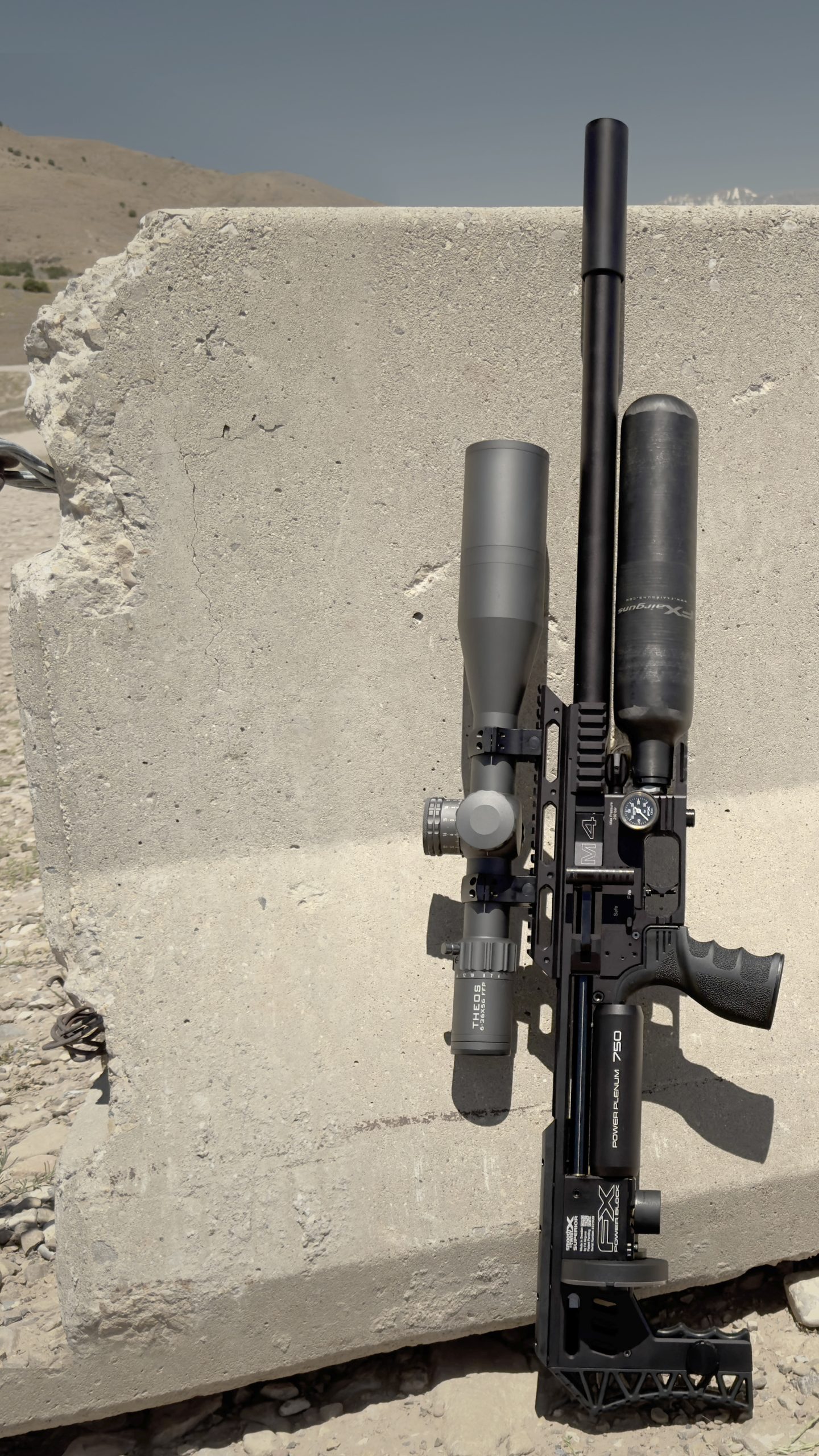 An air rifle standing upright against a concrete block