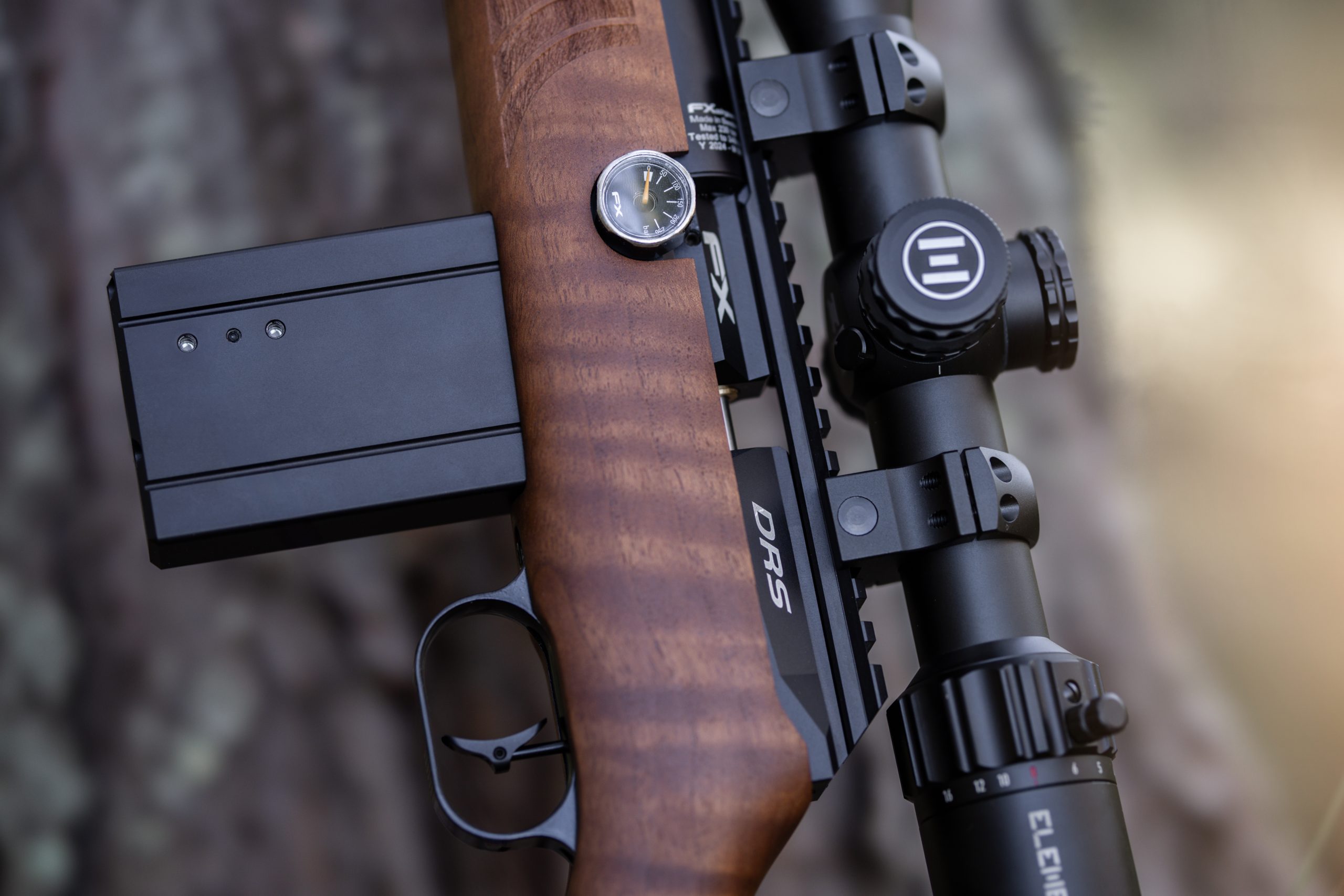 A close up of an air rifle with a wooden stock