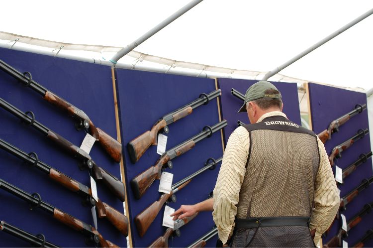 A man choosing a shotgun to buy